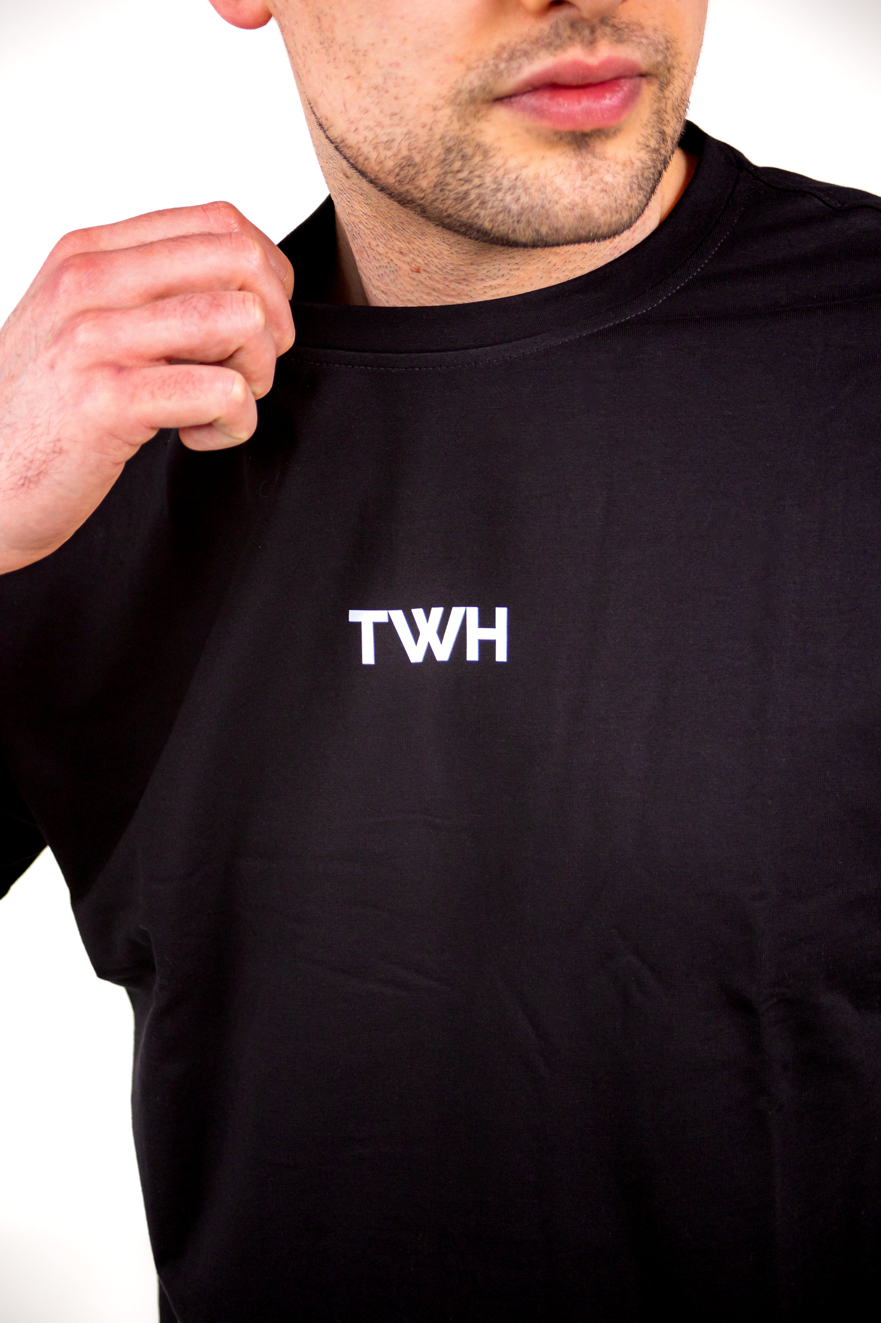 Person wearing a black hoodie with 'TWH' logo on a white background