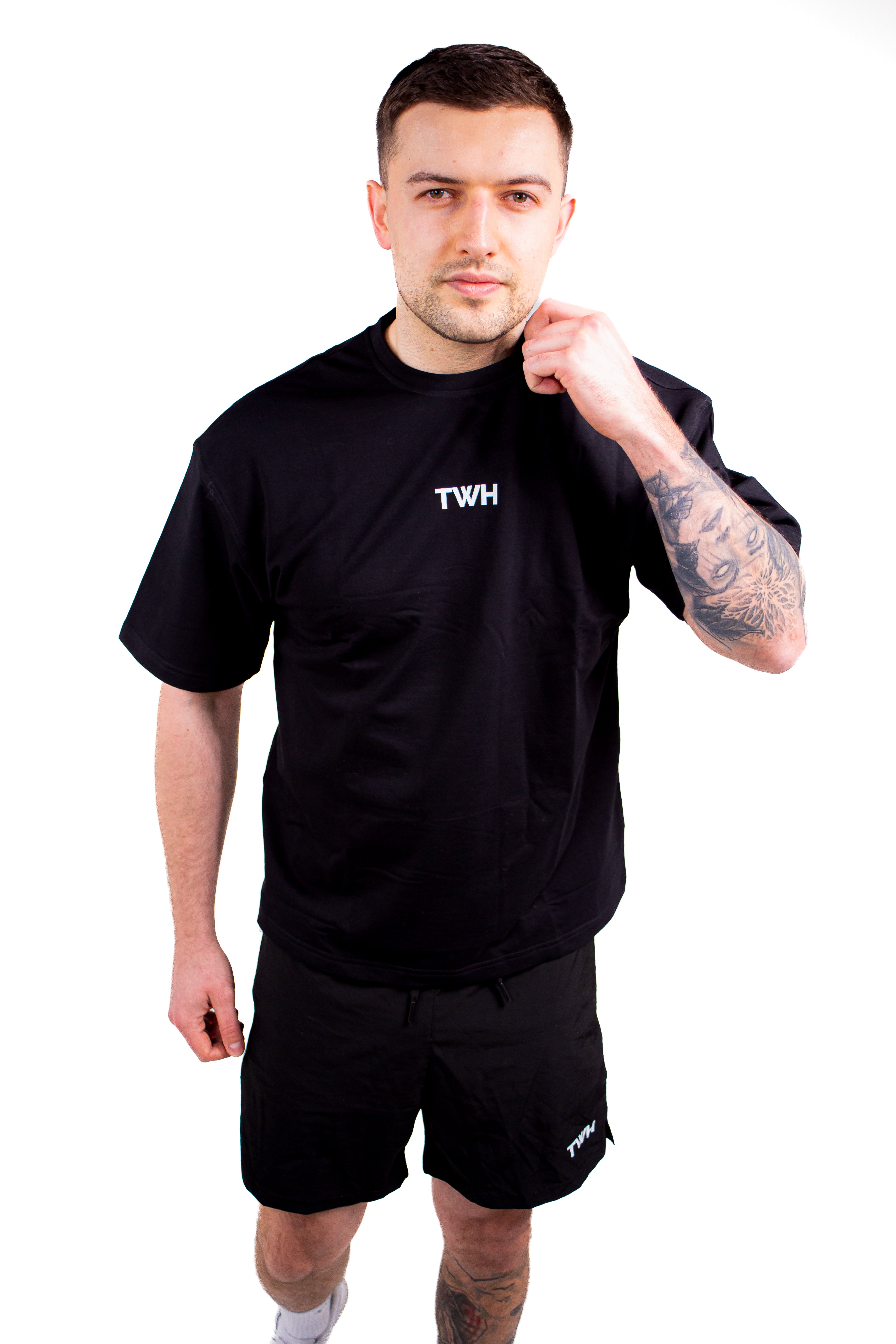 Man wearing a black t-shirt with 'TWH' logo on a white background